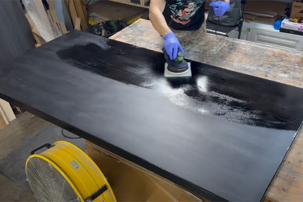 Sanding the tabletop surface coated with epoxy resin for high-glossy finish